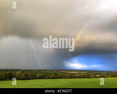 Meteo immagine frontale che mostra 4 stagioni, rainbow, sole, pioggia e fulmini in Pembrokeshire Wales, Regno Unito Foto Stock