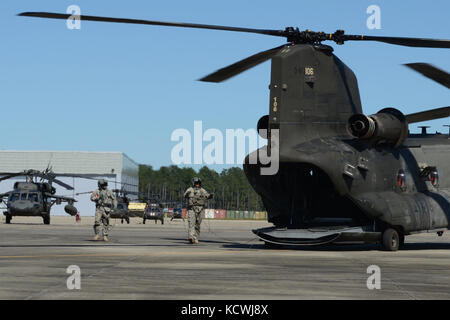 Un Sud Carolina guardâs nazionale ch-47f chinook, un pesante-lift elicottero configurato con una gamma estesa del sistema di alimentazione del carburante (erfs), a cui si fa riferimento anche come "vacca grassa", e il suo equipaggio assegnati a distacco 1, l'azienda b, 2-238th supporto generale del battaglione di aviazione, 59th aviazione il comando delle truppe da greenville s.c., le fasi della sua base di operazioni a sostegno dell'uragano matteo gli sforzi di recupero a mcentire comune di Guardia nazionale base, eastover, s.c., oct. 10, 2016. circa 2.000 Carolina del Sud la guardia nazionale di soldati e aviatori sono stati attivati a sostegno diretto di uragano Matteo resp Foto Stock