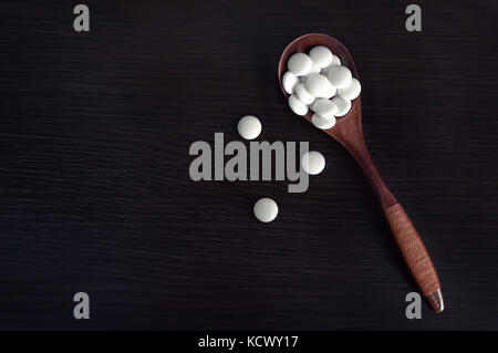 Assortiti medicina farmaceutica pillole, compresse a sul cucchiaio di legno Foto Stock