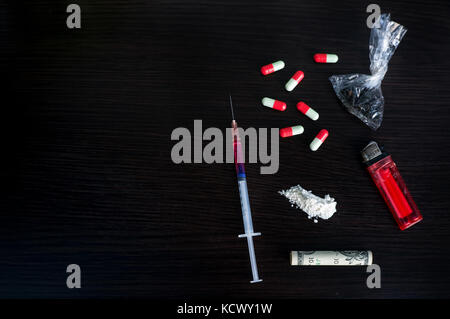 Siringa di farmaco e cotto eroina. Varie sostanze provoca dipendenza. vista superiore con spazio copia testo Foto Stock