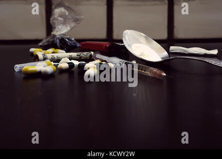 Droghe pesanti sul tavolo scuro. un tema scuro, l'uso di droga. Foto Stock