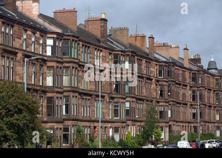 Guida in collina a Glasgow abitazioni in pietra arenaria rossa Foto Stock