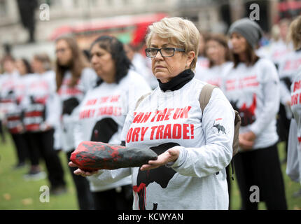 Centinaia di attivisti di Action for Elephants UK organizzano una protesta silenziosa a Parliament Square, Londra, per sensibilizzare la popolazione alla crisi bracconda che spinge rinoceronti ed elefanti all'estinzione e per esortare il governo ad attuare un divieto sul commercio di avorio nel Regno Unito. Foto Stock