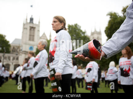 Centinaia di attivisti di Action for Elephants UK organizzano una protesta silenziosa a Parliament Square, Londra, per sensibilizzare la popolazione alla crisi bracconda che spinge rinoceronti ed elefanti all'estinzione e per esortare il governo ad attuare un divieto sul commercio di avorio nel Regno Unito. Foto Stock