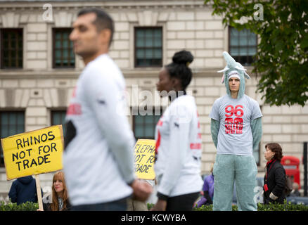 Centinaia di attivisti di Action for Elephants UK organizzano una protesta silenziosa a Parliament Square, Londra, per sensibilizzare la popolazione alla crisi bracconda che spinge rinoceronti ed elefanti all'estinzione e per esortare il governo ad attuare un divieto sul commercio di avorio nel Regno Unito. Foto Stock