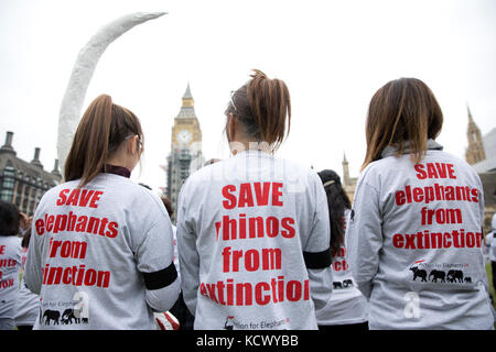 Centinaia di attivisti di Action for Elephants UK organizzano una protesta silenziosa a Parliament Square, Londra, per sensibilizzare la popolazione alla crisi bracconda che spinge rinoceronti ed elefanti all'estinzione e per esortare il governo ad attuare un divieto sul commercio di avorio nel Regno Unito. Foto Stock