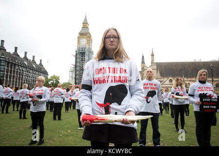 Centinaia di attivisti di Action for Elephants UK organizzano una protesta silenziosa a Parliament Square, Londra, per sensibilizzare la popolazione alla crisi bracconda che spinge rinoceronti ed elefanti all'estinzione e per esortare il governo ad attuare un divieto sul commercio di avorio nel Regno Unito. Foto Stock