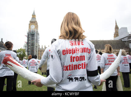 Centinaia di attivisti di Action for Elephants UK organizzano una protesta silenziosa a Parliament Square, Londra, per sensibilizzare la popolazione alla crisi bracconda che spinge rinoceronti ed elefanti all'estinzione e per esortare il governo ad attuare un divieto sul commercio di avorio nel Regno Unito. Foto Stock