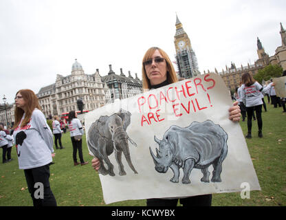 Centinaia di attivisti di Action for Elephants UK organizzano una protesta silenziosa a Parliament Square, Londra, per sensibilizzare la popolazione alla crisi bracconda che spinge rinoceronti ed elefanti all'estinzione e per esortare il governo ad attuare un divieto sul commercio di avorio nel Regno Unito. Foto Stock