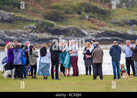 Wedding ceremony taking place outside with bride and groom kissing, Calgary Bay, Isle of Mull, Scotland, UK Foto Stock