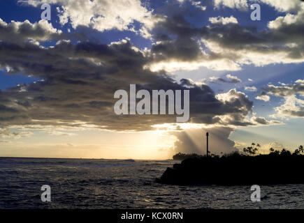 Tramonto attraverso le nuvole al porto di Kekaha, sul lato sud-ovest di Kauai, Hawaii, USA. Foto Stock