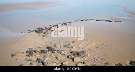 Pool di marea e sabbia / Banca di fango con rocce a bassa marea ed erosione di acqua fango allentati, la Baia di Cardiff, Cardiff, Regno Unito Foto Stock