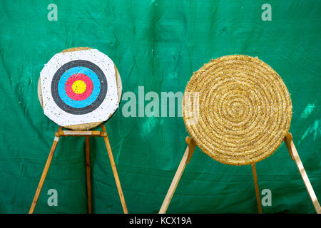 Due differenti tiro con l'arco anelli di destinazione durante una gara di tiro con l'arco. sfondo verde. Foto Stock