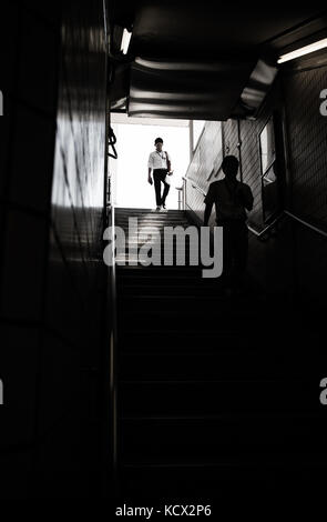 Un salaryman giapponese di entrare nella stazione della metropolitana. Foto Stock