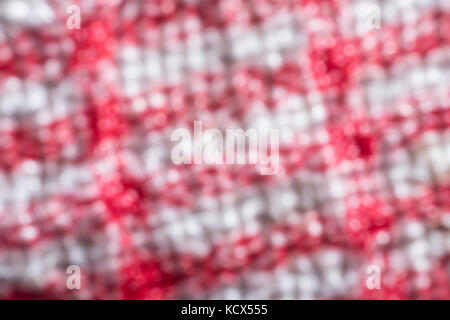 Macro shot rammolliti, sfocati, ravvicinato dei fili di ordito e trama di un teacloth rosso e bianco. Astratto rosso Foto Stock