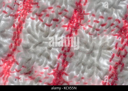 Macro shot rammolliti, sfocati, ravvicinato dei fili di ordito e trama di un teacloth rosso e bianco. Astratto rosso. Foto Stock