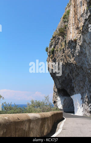 Piccolo tunnel attraverso il monte su strada stretta vicino al litorale Foto Stock