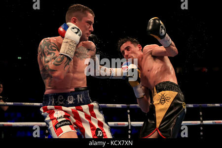 Anthony Crolla (a destra) in azione contro Ricky Burns durante il loro concorso di pesi leggeri alla Manchester Arena. Foto Stock