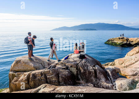 Gli escursionisti sulla battigia rocce nel Parco del faro, West Vancouver, British Columbia, Canada. Foto Stock