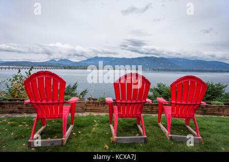 Tre rossi sdraio sedere nel cortile che si affaccia sul lago da sandpoint, Idaho. Foto Stock