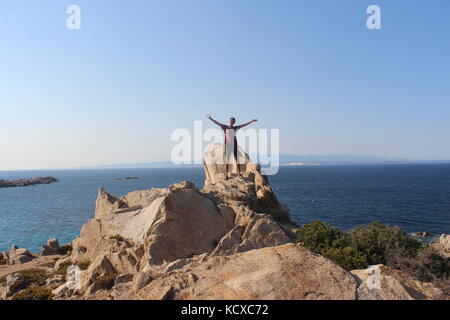 Punto falcone viewpoint a santa Teresa di Gallura. uomo in piedi in cima al rock. Foto Stock