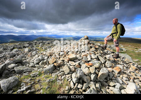 Walker al Vertice il tumulo di alta sollevare cadde, Parco Nazionale del Distretto dei Laghi, Cumbria County, Inghilterra, Regno Unito. Sollevamento elevato è caduto è uno dei 214 Foto Stock