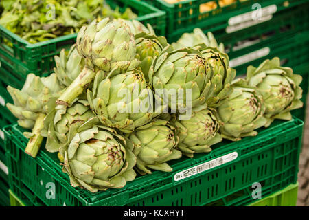 Cassa verde con carciofi freschi sul mercato Foto Stock