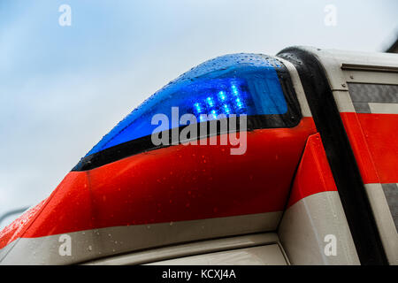 Ambulanza flash luce blu in un giorno di pioggia Foto Stock