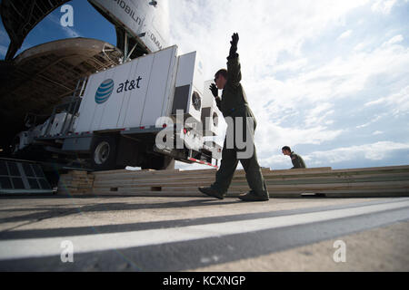 Master Sgt. Steve Brewer, un loadmaster assegnato al nono Airlift Squadron, Dover Air Force Base, Delaware, guida una AT&T torre di telecomunicazioni al di fuori di un C-5M Super galassia a Luis Muñoz Marín International Airport, Puerto Rico, 6 ott. 2017. Il C-5M trasportato torri da AT&T, per fornire copertura di telecomunicazione per le aree in Puerto Rico più colpiti dall uragano Maria. Si tratta di un'iniziativa del presidente Donald Trump le priorità per i tentativi di recupero in Puerto Rico. (U.S. Air Force foto di Tech. Sgt. Larry E. Reid Jr., rilasciato) Foto Stock