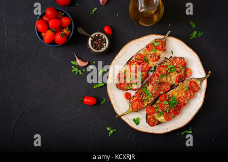 Melanzane al forno con mozzarella e pomodoro con erbe italiane. flat laici. vista superiore Foto Stock