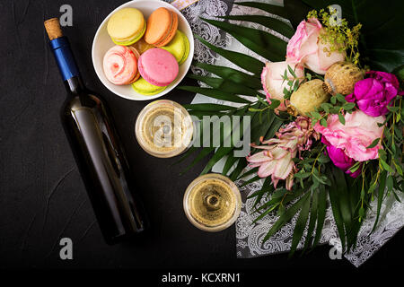 Bottiglia di vino bianco secco e un amaretto. flat laici. vista dall'alto. Foto Stock