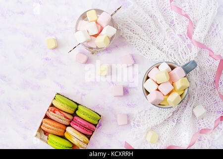 Amaretti colorati e marshmallows su uno sfondo luminoso. flat laici. vista superiore Foto Stock