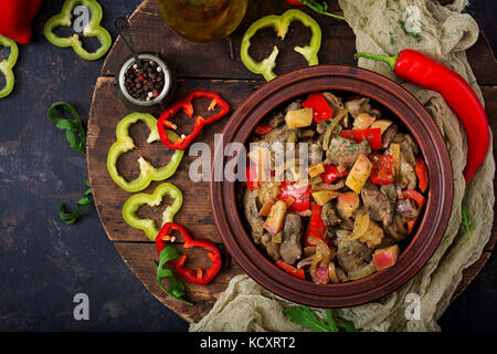 Arrosto di fegato di pollo con verdure su sfondo di legno. flat laici. vista superiore Foto Stock