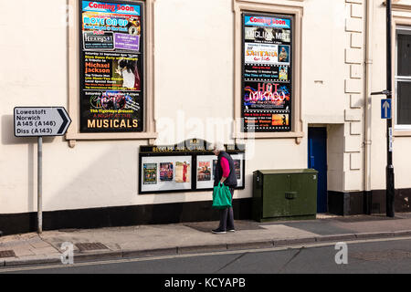 Una donna guarda al poster sulla parete di beccles pubblico e sala teatro, BECCLES, SUFFOLK, Regno Unito Foto Stock