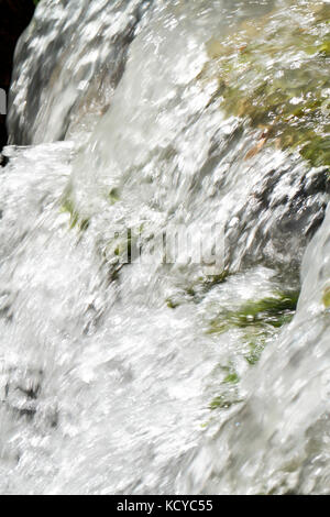 Torrente di acqua in cascata la rottura nelle rocce Foto Stock