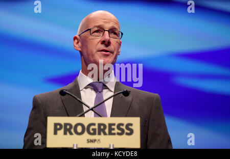 Il Vice primo Ministro della Scozia John Swinney presenta il discorso di apertura ai delegati della conferenza del Partito Nazionale Scozzese (SNP) presso il SEC Centre di Glasgow. Foto Stock