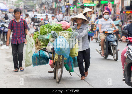 A Saigon, Vietnam - Giugno 2017: donna nel cappello conico per la vendita di frutta sulla strada, a Saigon, Vietnam. Foto Stock