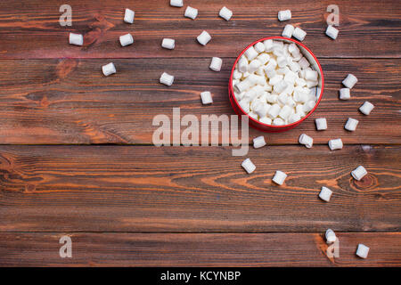 Marshmallow in una casella su un sfondo di legno. Foto Stock