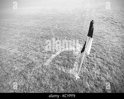 Bianco bandiera blu in un angolo del parco giochi di calcio, lazy vento Foto Stock