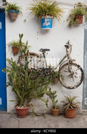 Rusty bicicletta appesa sul muro, Palma di Maiorca, isole Baleari, Spagna. Foto Stock