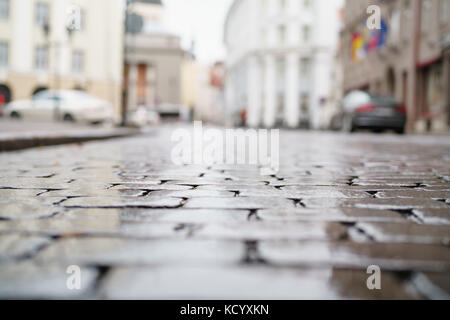 Bassa angolazione del wet vecchio marciapiede in Tallinn con messa a fuoco poco profonda Foto Stock