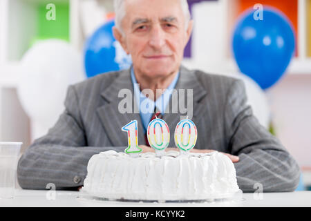 Senior uomo con la torta su un centesimo compleanno Foto Stock