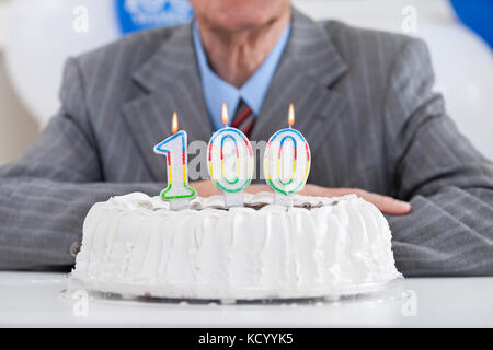 Torta di compleanno con candele accese per un secolo, il centesimo compleanno Foto Stock