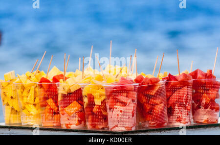 Tagliare ananas e anguria in bicchieri di plastica con stuzzicadenti Foto Stock