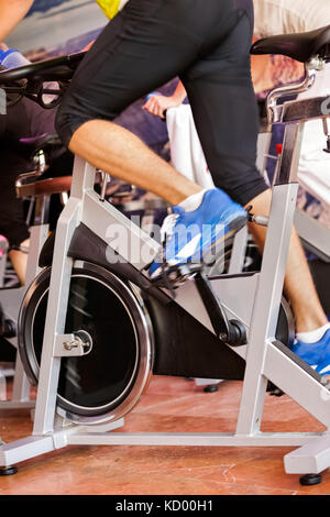 Uomo in palestra facendo esercizio in bici Foto Stock