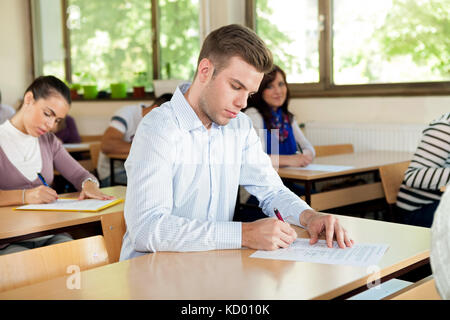 Buona ricerca studente prende appunti in un anfiteatro Foto Stock