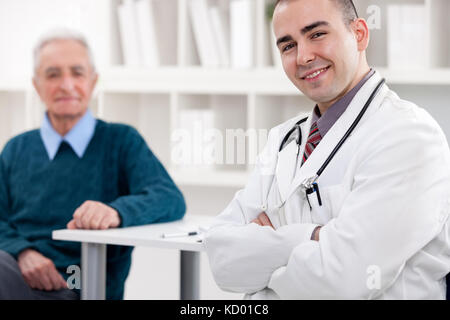 Successo giovane medico con il paziente in background Foto Stock