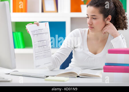 Ragazza di studenti in possesso di una carta di prova con una mancanza di grado Foto Stock