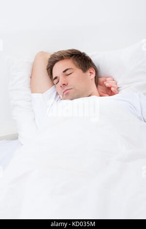 Ritratto di giovane uomo dorme nel letto Foto Stock