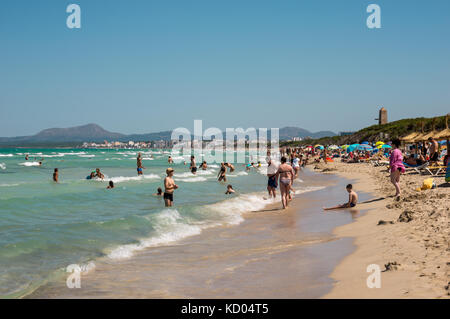 I turisti in Playa de muro beach con Can Picafort città e le montagne sullo sfondo, la parte settentrionale dell'isola di Maiorca Foto Stock